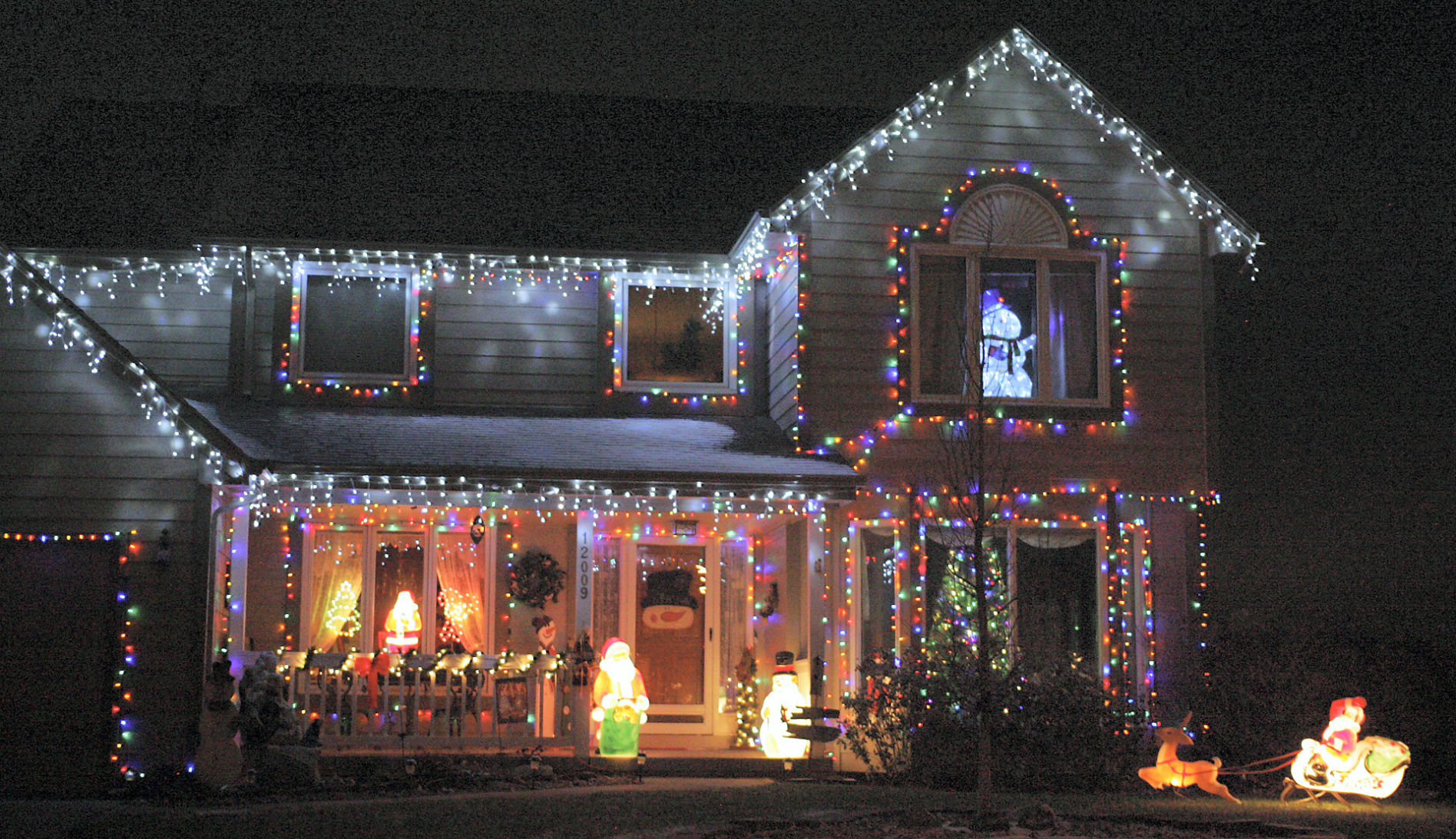 A snowman peeks out of an upstairs window of this Christmas light display off Quail Drive in Plum Creek.